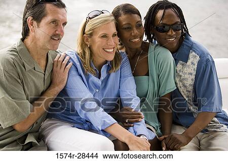 Cheerful mid adult couples sitting together View Large Photo Image Picture - Cheerful mid adult couples sitting together. Fotosearch