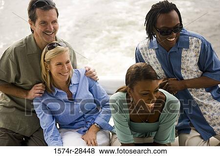 Cheerful mid adult couples sitting together View Large Photo Image Stock Photo - Cheerful mid adult couples sitting together. Fotosearch