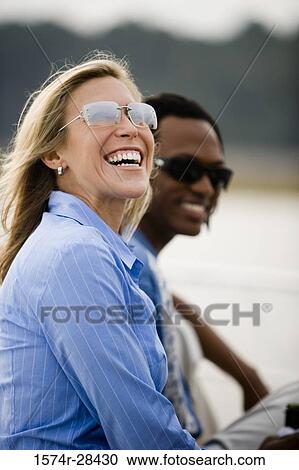 Cheerful mid adult woman wearing sunglasses and looking away View Large Photo Image Stock Image - Cheerful mid adult woman wearing sunglasses and looking away. Fotosearch