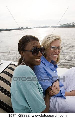Cheerful mid adult women enjoying on the deck of a boat View Large Photo Image Stock Image - Cheerful mid adult women enjoying on the deck of a boat. Fotosearch