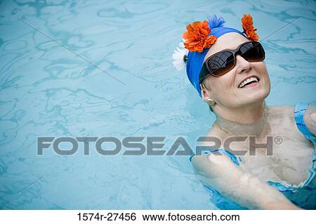 Cheerful senior women smiling and swimming in a swimming pool View Large Photo Image Stock Photograph - Cheerful senior women smiling and swimming in a swimming pool. Fotosearch