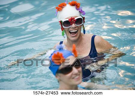 Cheerful senior women swimming in a swimming pool View Large Photo Image Stock Image - Cheerful senior women swimming in a swimming pool. Fotosearch