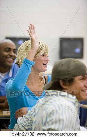 Cheerful students attending lecture while one female student raising her hand in the classroom View Large Photo Image Stock Image - Cheerful students attending lecture while one female student raising her hand in the classroom. Fotosearch