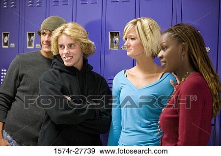 Cheerful students with female teacher standing by lockers and looking away View Large Photo Image Stock Photo - Cheerful students with female teacher standing by lockers and looking away. Fotosearch