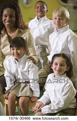 Cheerful teacher sitting with students View Large Photo Image Stock Photograph - Cheerful teacher sitting with students. Fotosearch