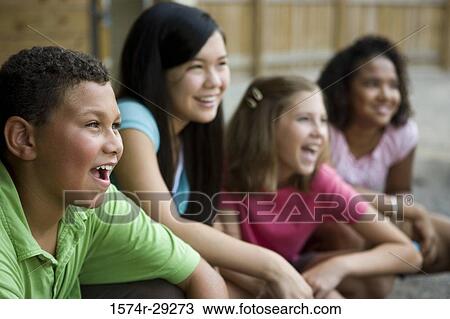 Stock Image - Cheerful teenager sitting together and smiling. Fotosearch