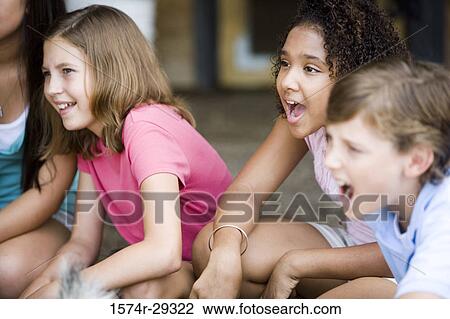 Stock Image - Cheerful teenagers sitting together. Fotosearch