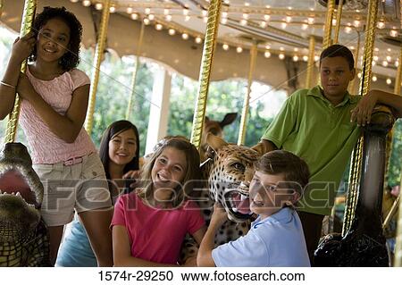 Cheerful teenagers standing in a carousel View Large Photo Image Stock Image - Cheerful teenagers standing in a carousel. Fotosearch
