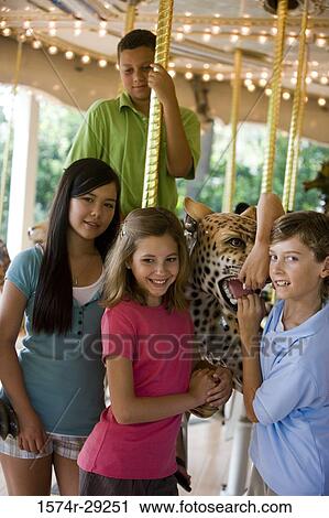 Stock Image - Cheerful teenagers standing in a carousel. Fotosearch