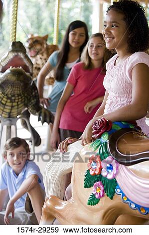 Stock Photo - Cheerful teenagers standing in a carousel. Fotosearch
