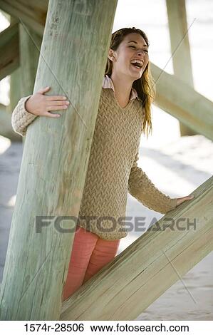 Cheerful woman standing by columns View Large Photo Image Stock Photograph - Cheerful woman standing by columns. Fotosearch