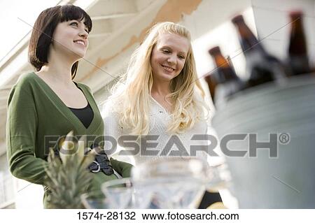 Cheerful women smiling by house View Large Photo Image Stock Image - Cheerful women smiling by house. Fotosearch