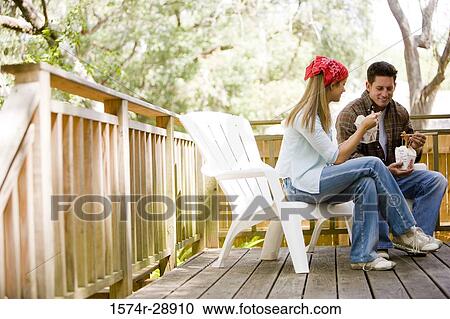 Cheerful young couple eating noodles on armchairs View Large Photo Image Stock Image - Cheerful young couple eating noodles on armchairs. Fotosearch
