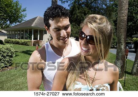 Stock Photo - Cheerful young couple on lawn. Fotosearch
