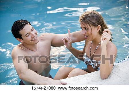 Cheerful young couple talking in swimming pool View Large Photo Image Stock Image - Cheerful young couple talking in swimming pool. Fotosearch