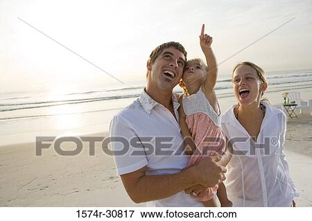 Cheerful young couple with daughter on the beach View Large Photo Image Stock Photo - Cheerful young couple with daughter on the beach. Fotosearch