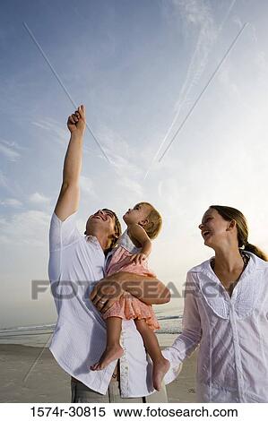Cheerful young couple with daughter on the beach View Large Photo Image Stock Photography - Cheerful young couple with daughter on the beach. Fotosearch