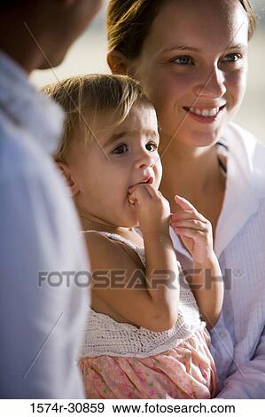 Stock Photo - Cheerful young couple with daughter. Fotosearch