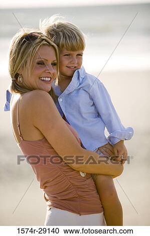 Cheerful young woman with her son at the beach View Large Photo Image Stock Image - Cheerful young woman with her son at the beach. Fotosearch