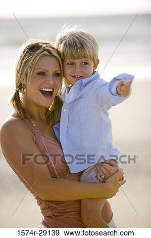 Cheerful young woman with her son at the beach View Large Photo Image Stock Photo - Cheerful young woman with her son at the beach. Fotosearch