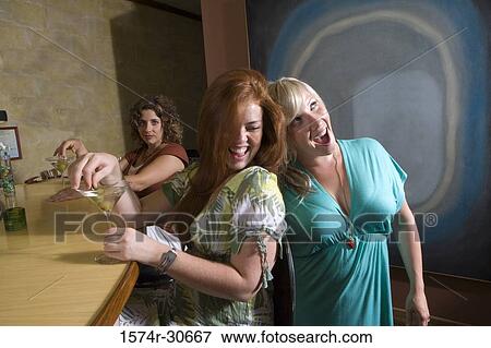 Cheerful young woman with mother by bar counter with sister behind View Large Photo Image Stock Photo - Cheerful young woman with mother by bar counter with sister behind. Fotosearch
