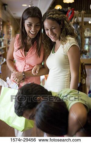 Cheerful young women standing with shopping bags while children in foreground View Large Photo Image Stock Photograph - Cheerful young women standing with shopping bags while children in foreground. Fotosearch