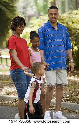 Children holding hands of their parents walking on the road View Large Photo Image Stock Photograph - Children holding hands of their parents walking on the road. Fotosearch