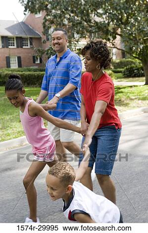 Children holding hands of their parents walking on the road View Large Photo Image Stock Photography - Children holding hands of their parents walking on the road. Fotosearch