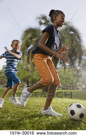 Children playing soccer ball at park View Large Photo Image Stock Photograph - Children playing soccer ball at park. Fotosearch