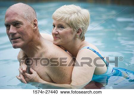 Close of a senior woman embracing a man in swimming pool View Large Photo Image Stock Image - Close of a senior woman embracing a man in swimming pool. Fotosearch