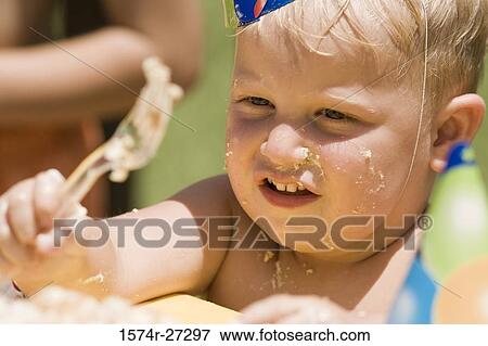 Close-up of a boy holding folk at birthday party View Large Photo Image Stock Photo - Close-up of a boy holding folk at birthday party. Fotosearch
