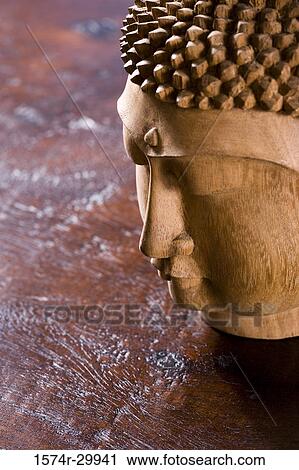 Stock Image - Close-up of a Buddha statue kept on the table. Fotosearch