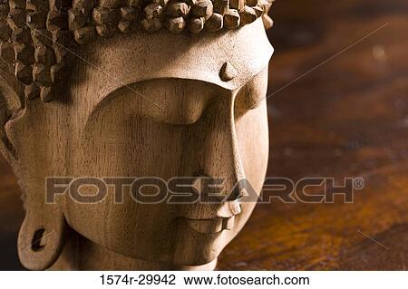 Stock Image - Close-up of a Buddha statue kept on the table. Fotosearch