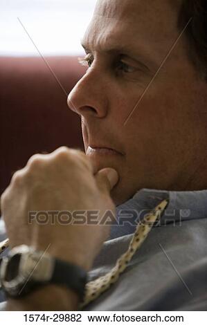 Close-up of a businessman sitting with his hand on chin View Large Photo Image Stock Image - Close-up of a businessman sitting with his hand on chin. Fotosearch