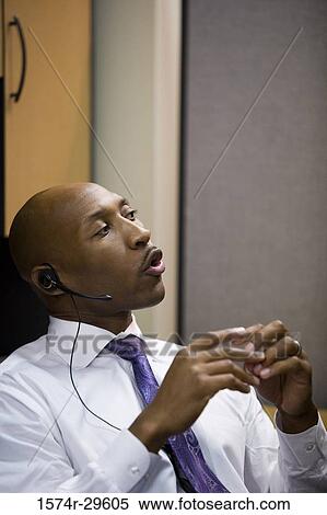 Close-up of a businessman with headset in an office View Large Photo Image Stock Photography - Close-up of a businessman with headset in an office. Fotosearch