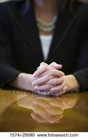 Stock Image - Close-up of a businesswoman with hands clasped. Fotosearch