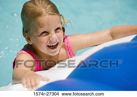 Close-up of a cheerful girl looking up at swimming pool View Large Photo Image Picture - Close-up of a cheerful girl looking up at swimming pool. Fotosearch