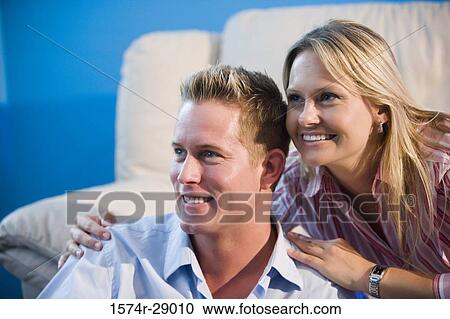 Close-up of a cheerful mid adult couple looking away in a house View Large Photo Image Stock Image - Close-up of a cheerful mid adult couple looking away in a house. Fotosearch
