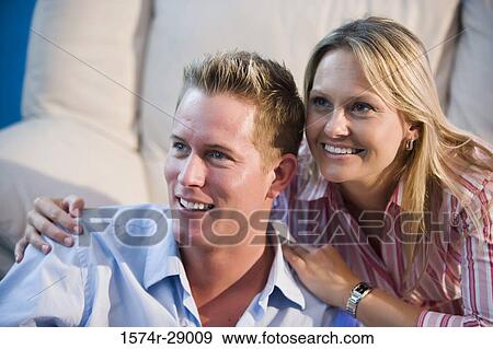 Close-up of a cheerful mid adult couple looking away in a house View Large Photo Image Stock Photo - Close-up of a cheerful mid adult couple looking away in a house. Fotosearch