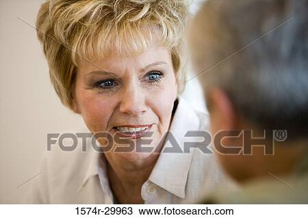 Stock Image - Close-up of a cheerful woman looking at man. Fotosearch
