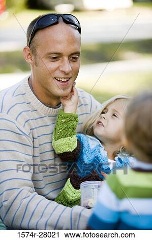 Close-up of a father sitting with his children View Large Photo Image Stock Image - Close-up of a father sitting with his children. Fotosearch