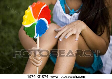 Close-up of a girl holding lollipop View Large Photo Image Picture - Close-up of a girl holding lollipop. Fotosearch
