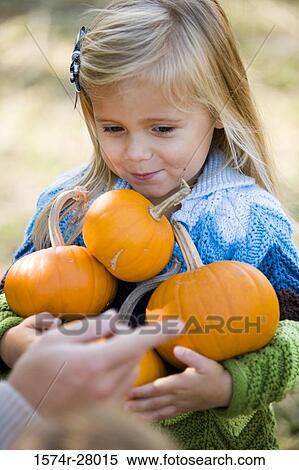 Close-up of a girl holding pumpkins View Large Photo Image Stock Photography - Close-up of a girl holding pumpkins. Fotosearch