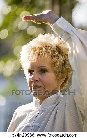 Close-up of a mature woman performing martial arts in the park View Large Photo Image Stock Photograph - Close-up of a mature woman performing martial arts in the park. Fotosearch