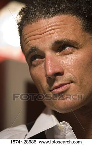 Close-up of a mid adult man looking away View Large Photo Image Stock Photograph - Close-up of a mid adult man looking away. Fotosearch