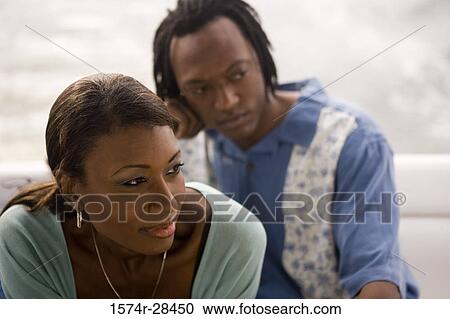 Close-up of a mid adult woman smiling with man in the background View Large Photo Image Stock Image - Close-up of a mid adult woman smiling with man in the background. Fotosearch