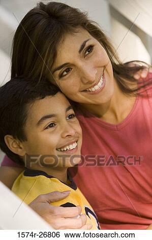 Close-up of a mother embracing her son View Large Photo Image Stock Photograph - Close-up of a mother embracing her son. Fotosearch