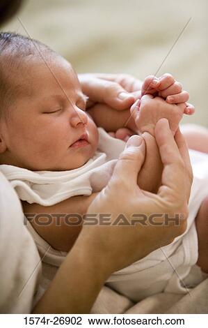Stock Image - Close-up of a newborn in human hand. Fotosearch