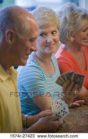 Stock Image - Close-up of a senior men and women playing cards. Fotosearch
