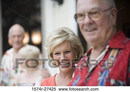 Stock Photography - Close-up of a senior people standing outside house and smiling. Fotosearch